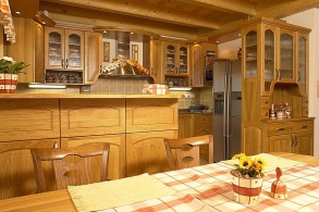 Pracovní plocha v kuchyni se skrývá za barovým pultem. Kuchyňská linka byla vyrobena na míru, design odpovídá venkovskému stylu