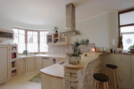 Kuchyňská linka byla vyrobena na míru z masivního javoru. V souladu se zásadami celostní architektury je obrácena na východ a vymalována zelenou barvou, s níž příjemně ladí šedozelená oblázková mozaika
