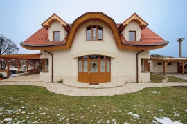 Příchozí vítají velké vstupní dveře umístěné na ose hlavní jižní fasády. Souměrnost podle svislé osy je významnou vlastností utvářející se přírody, proto symetrická architektura dobře působí na naši psychiku. Příjemné pocity jsou také podpořeny oblými tvary