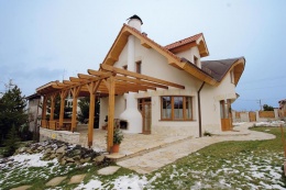 Na fasádě členitého domu harmonicky souzní čtyři základní materiály přírodního původu - dřevo, hladká štuková omítka, pískovec (sokly, okenní nadpraží, dlažby) a pálená tašková krytina. Ze západní strany byla přestavěna velká, částečně zastřešená pergola navazující na venkovní krb