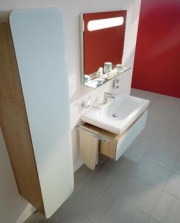 Skříňky s dýhou z dubového dřeva upoutají kontrastem materiálů a barev. Skříňka pod umyvadlo (75 cm) s kontejnerem stojí 23 237 Kč, vysoká skříňka 33 365 Kč, zrcadlo s osvětlením a poličkou je za 27 113 Kč