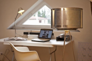 Perforovaný plech se opakuje i na stojací lampě, jejíž stínidlo je ze staré pračky. Stolní lampu TOLOMEO MINI vyrábí ARTEMIDE 