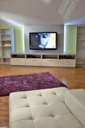 Rozkládací sedačka a dvě barové židle jsou ve světlé kůži 