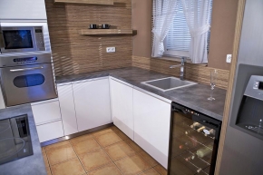 Pracovní deska v designu betonu a granitový dřez se barevně propojují