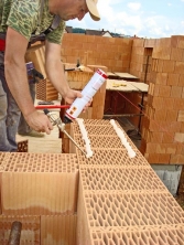 Zdění na PUR pěnu Dryfix Porotherm. Výhodou je možnost stavění  v zimním období až do teplot –5 °C