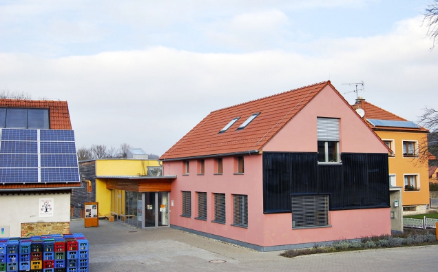 Budova Centra Veronica se solárním kolektorem na čelní fasádě, vlevo moštárna.