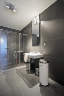 Víkendovému užívání postačí sprchový kout. Architektka navrhla řešení přes celou šíři místnosti