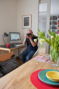 Pracovní stůl má konstrukci ze dřeva a pracovní desku z černého laminátu, vizuálně navazuje na černobílou fotografii nad stolem, kterou také rámuje dub