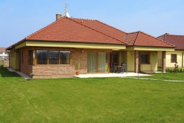 Na fasádě se jasně projevuje příklon přírodnímu stylu v moderním pojetí. Pálené tašky Tondach majitelé domu zkombinovali s režným cihelným obkladem a s omítkou olivové barvy