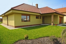 Na fasádě se jasně projevuje příklon přírodnímu stylu v moderním pojetí. Pálené tašky Tondach majitelé domu zkombinovali s režným cihelným obkladem a s omítkou olivové barvy