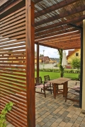 Členitější vzhled dodala domu dřevěná pergola, obíhající roh stavby a zastřešující terasu u obytné části přízemí