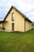 Členitější vzhled dodala domu dřevěná pergola, obíhající roh stavby a zastřešující terasu u obytné části přízemí