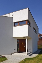 Funkci stříšky nad vstupními dveřmi přejímá přesahující horní podlaží