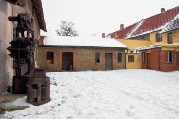 Hlavními vraty se vchází na dvůr obklopeným čtyřmi stodolami