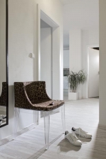 Předsíň souzní s protější koupelnou. Jediným tmavým prvkem je křesílko Mademoiselle (design Philippe Starck, látka Dolce & Gabbana)