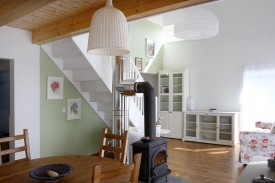 Do podkroví vede nejen schodiště, ale i nerezový komín, technický prvek, který tvoří zajímavý protiklad k zařízení v tradičním stylu. Horizontální okna ve štítě přidávají působivé horní osvětlení