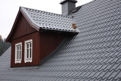 Na připravené bednění byla položena kontaktní difúzní folie a laťování skládající se z kontralatí a latí rozměru 40 x 60mm. Díky kontralatím byla zajištěna dostatečná větrací mezera, pro odvětrání střešního pláště starého domu. Vzhledem k tomu, že obě střešní plochy mají proměnlivý spád, zhruba v 1/3 dochází k drobnému zlomu, bylo nutné tento přechod vyřešit. V tomto případě byla krytina u okapu odsazena o pár centimetrů od hrany okapového plechu, což je z funkčního i estetického hlediska zcela v pořádku