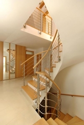 Velkorysá schodišťová hala s hormín osvětlením a elegantní linii schodiště patří k autorskému rukopisu architekta Houši