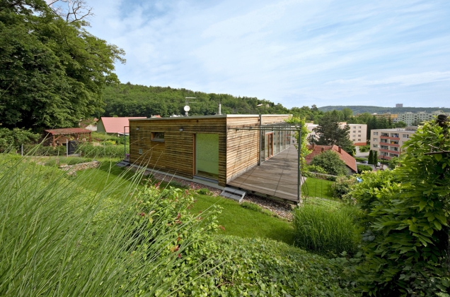 Architektura podélné dvoupodlažní budovy s plochou střechou má proto formu prostorově úsporného domu s minimálně členěným půdorysem.