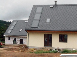 Ekosídliště v Koberovech jde cestou sériových nízkonákladových pasivních domů. To, co při pohledu zvenčí vypadá jako méně běžná střešní okna, jsou ve skutečnosti solární kolektory integrované do střešní krytiny. Jsou umístěné ve svislé linii (od okapu po hřeben), a tím usnadňují sklouzávání sněhu z absorpční plochy a umožňují vyšší energetické zisky v zimním období