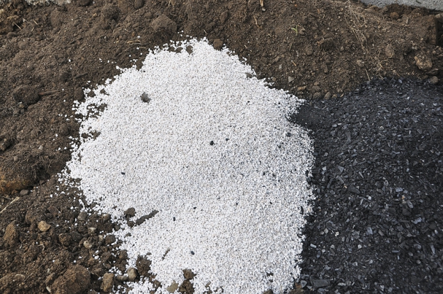 Černá a bílá v harmonii. Perlit a drcené dřevěné uhlí, dvě nejpraktičtější přírodní substance pro vylehčení půdy v záhonech. Poskytnou výborné životní podmínky mikroskopickým půdním organismům. Tyto organismy a jejich výměšky jsou ve skutečnosti tím, co živí naše rostliny.