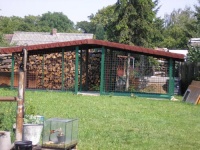 Kovovou konstrukci kotce natřeli zelenou barvou, aby lépe zapadl do zeleně zahrady