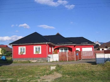 Dnes už je dům příjemně zabydlený, díky malinově červené fasádě je nepřehlédnutelný
