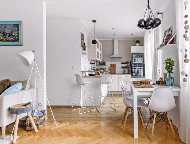 Pojícím prvkem kuchyně a obývacího pokoje je jídelna s bílým stolem a designovými židlemi. Zajímavým detailem jsou závěsná svítidla zakoupená v pražské prodejně Elusia.