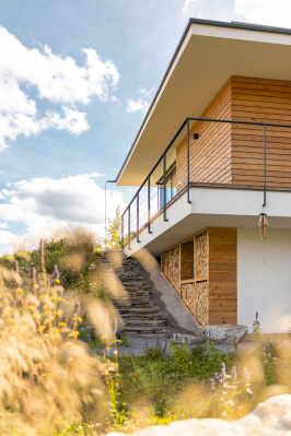 Dům ukrytý mezi horami u Žiliny vyniká propojením architektury s okolím. Celkové vyznění přirozenosti a jednoduchosti podtrhuje i projekt zahrady, která je inspirována původními rostlinami a dřevinami. I když původně chtěl majitel použít dřevo i při výstavbě domu, pro atypicky tvarovaný dům se jako mnohem vhodnější ukázal pórobeton Ytong. (Zdroj: Xella CZ)
