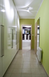 Do prostorné chodby se vešla řada vysokých skříní, které poskytují velké úložné prostory, další nabízí malá šatna v ložnici. Jedním z jenotících prvků tu jsou reflektorová stropní svítidla, která vedou v jedné rovině z kuchyňského koutu předsíní do koupelny
