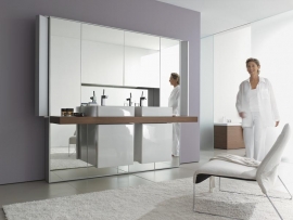 Systém Mirrorwall ve dvojitém provedení se dvěma monobloky a postranním sloupkovým osvětlením. Nad umyvadly jsou schované skříňky