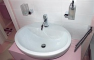 Robustní umyvadlo posazené na skříňce je vybaveno baterií značky GESSI. Ze stejné kolekce Quadro jsou i ostatní doplňky