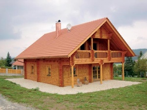 Klasická roubená dřevostavba z průmyslově opracovaných kmenů polární borovice. Tloušťka stěn 210 mm, typické křížové spoje. Povrchová úprava lazurou na bázi cedrových pryskyřic (MS Haus, orientační cena horní stavby na klíč 26 500 Kč/metr čtvereční)