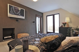 Neutrální tlumené barvy, ratan a vhodně volené textilie a přilehlý balkon dělají z ložnice působivé místo k odpočinku