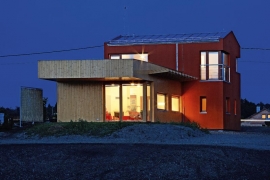 Architektonický výraz domu sází na kontrasty. Směrem k ulici se tyčí dvoupodlažní hmota s výraznou červenou omítkou, do zahrady směřuje přízemní přístavba s dřevěným obložením. Na jižní fasádu architekt navrhl atypický dřevěný slunolam