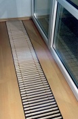 Podlahové konvektory Carlo dodává firma CLAGE v délkách od 130 do 500 cm (šířka 29,2 cm, hloubka 12 cm, cena 5 987-20 510 Kč). Obsahují dva smostatné topné výměníky Panel-Trim bez ventilátoru a při teplotním spádu 75/65 stupňů Celsia dávají topný výkon od 480 do 2 020 W. Lze je osadit různými podlahovými mřížkami