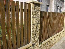Zděná konstrukce obložená štípaným betonem s plotovými výplněmi ze dřeva
