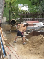 Kamarádi míchali venku beton a tahali ho nahoru na verandu