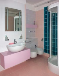 Příčka ze skleněných tvárnic odděluje místnost od dětské koupelny. Toaleta a bidet jsou ve výklenku za umyvadlem. Místnost opticky zvětšuje dostatek svítidel i dvě velká zrcadla