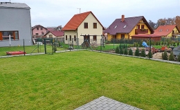 Nesourodou zástavbu v okolí pohledově oddělí zelená bariera z vyšších stromů a keřů. Pouze ve vztahu k severním sousedům zůstává zachován vizuální kontakt, aby bylo možné kontrolovat společné dětské hrátky