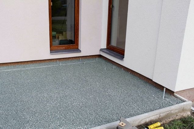Podkladní vrstvu pro pokládku terasy tvoří 10 cm silná zhutněná vrstva kamenné drti frakce 4 až 8 mm, vyspádovaná na trávník.
