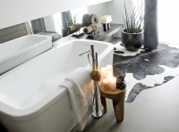 Potlačená barevnost přechází i do koupelny. Keramické obklady jsou použity jen na podlaze a ve sprchovém koutu. Relaxační místnost dotvářejí kožešina, palmové květináče, etno artefakty i svíčky na starých indických hmoždířích… to vše příspíva k zenové atmosféře.