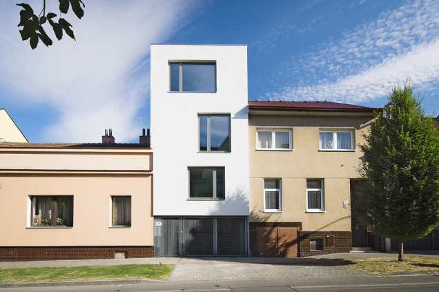 Dům vyrostl po rekonstrukci o patro výše a získal tak funkcionalistický nádech. Vstup a vjezd do garáže oddělují od ulice pouze mříže (stavební systém Ytong)