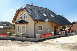 Valbová střecha, tašková krytina, členění a orámování oken jsou variací na tradiční architekturu 