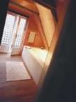  Podlaha z běleného smrku vyvedená skrze koupelnu až na balkon, zvyšuje homogenní charakter celého interiéru 