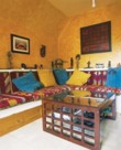  Žlutý „africký“ pokoj - celek. Potahy na sedačce jsou z alžírského koberce. Barvy: poušť a slunce 