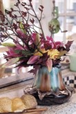  Srdcem nádherné kytice jsou nakvétající lilie (Lilium), okrové jiřinky (Dahlia) a dubové listí. Podzimní atmosféru dotváří tmavě červené klokaní tlapky (Anigozanthos) 