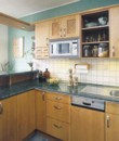  Úložného prostoru je v nové kuchyni dostatek. Přírodní dřevo v kombinaci s kovovými doplňky působí elegantně 