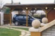  Přístřešek pro auto, pod jeho protaženou střechou vede i chráněný přístup od vstupní branky k domu 