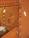  Osvětlení u zrcadla (LINEA BETA) lze nastavit podle výšky postavy. Součástí obdélníkového zrcadla je i menší kulaté zvětšovací zrcátko 